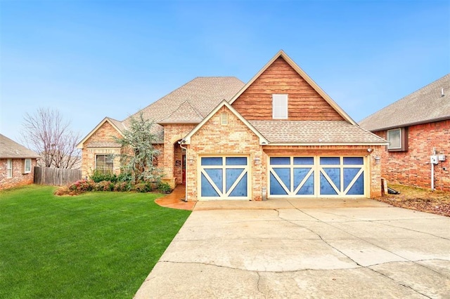 view of front of house featuring a front yard, concrete driveway, roof with shingles, and brick siding