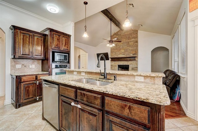 kitchen with a center island with sink, visible vents, appliances with stainless steel finishes, open floor plan, and a sink