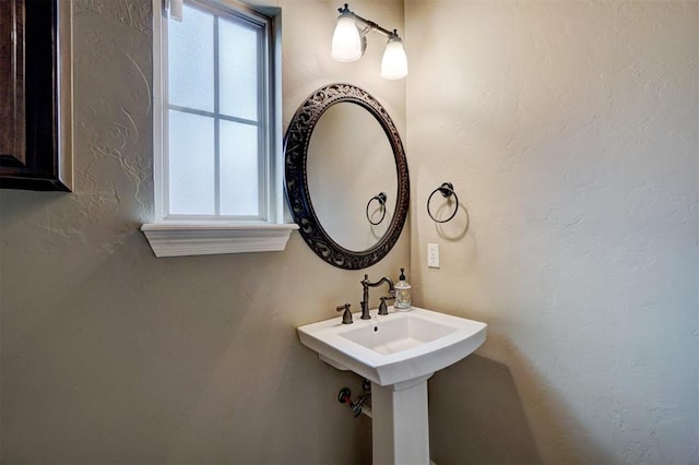 bathroom featuring a wealth of natural light and a textured wall