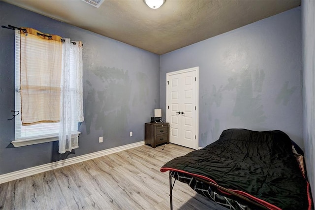 bedroom with baseboards and wood finished floors