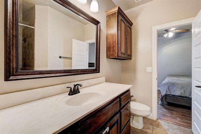 full bath with ensuite bath, vanity, toilet, and a ceiling fan