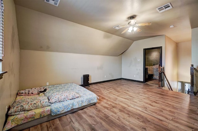 bedroom featuring lofted ceiling, wood finished floors, visible vents, and baseboards