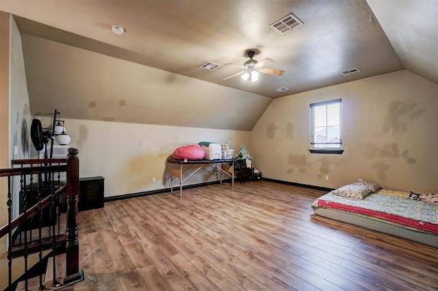 additional living space with visible vents, vaulted ceiling, and wood finished floors