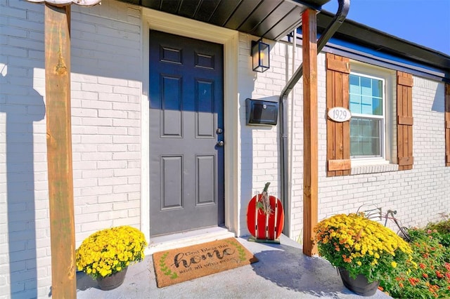 view of exterior entry with brick siding