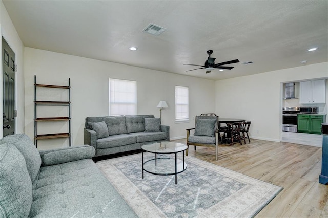 living area featuring light wood-style floors, baseboards, visible vents, and recessed lighting