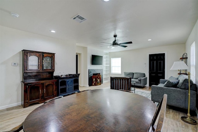 dining space featuring built in shelves, visible vents, light wood-style flooring, and baseboards