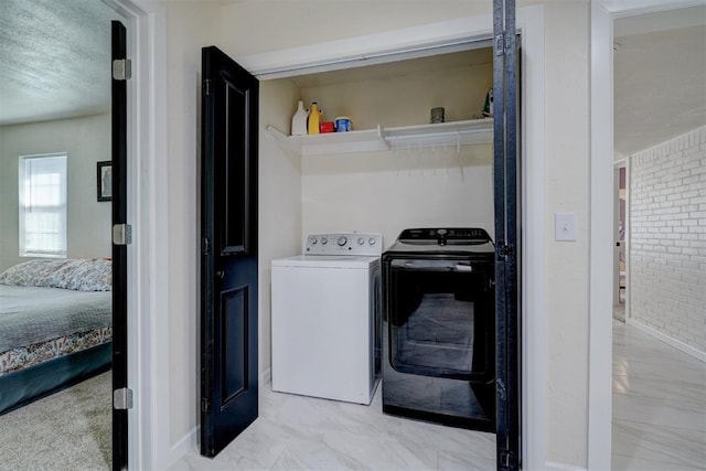 laundry area featuring laundry area, independent washer and dryer, marble finish floor, and a textured ceiling