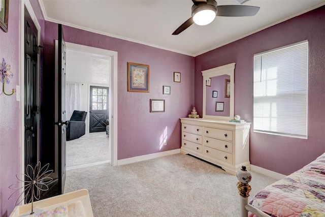 carpeted bedroom featuring a ceiling fan, crown molding, and baseboards