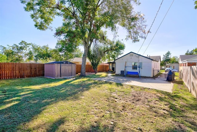 view of yard featuring a patio area, an outdoor structure, and a fenced backyard