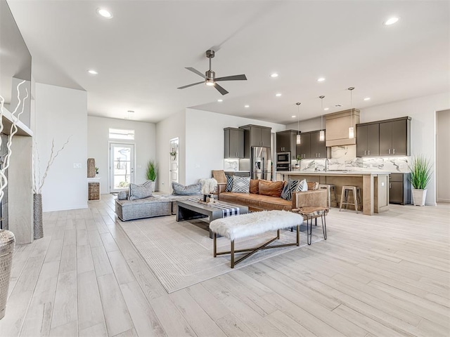 living room featuring a ceiling fan, light wood-type flooring, and recessed lighting