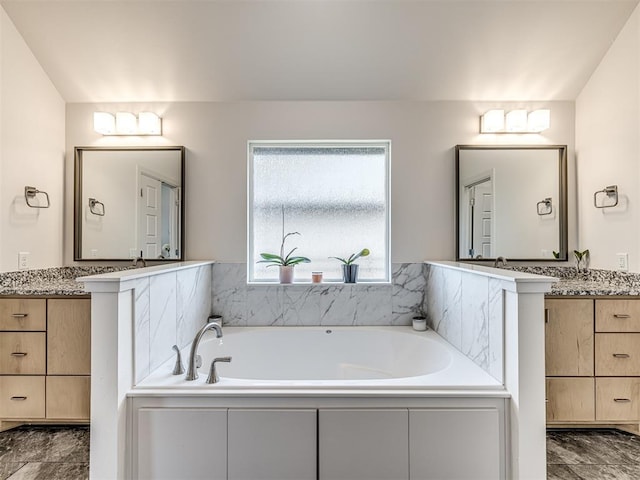 full bath featuring two vanities and a bath