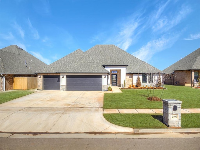 view of front of home with a garage, brick siding, concrete driveway, roof with shingles, and a front lawn