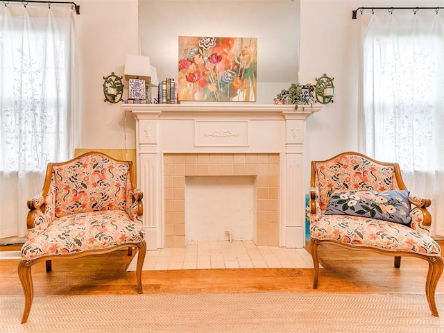 sitting room with a fireplace and wood finished floors