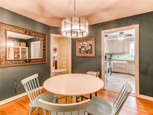 dining area with light wood finished floors, ceiling fan, and baseboards