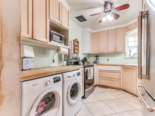 washroom with light tile patterned flooring, washing machine and dryer, laundry area, visible vents, and crown molding