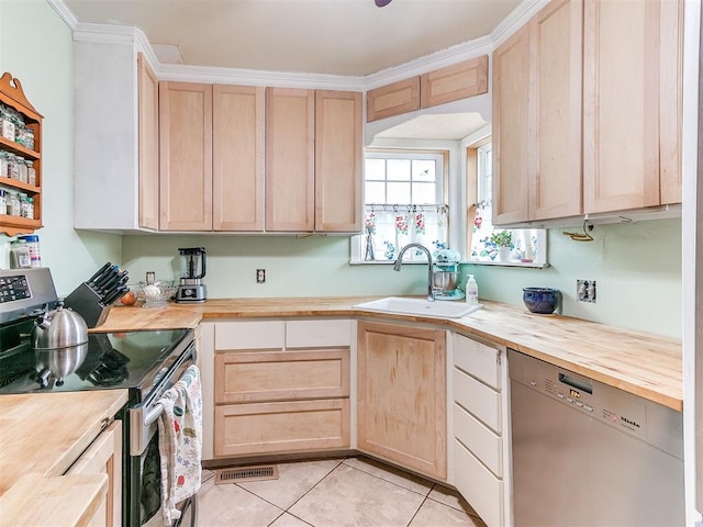 kitchen with stainless steel appliances, light brown cabinets, wooden counters, and a sink