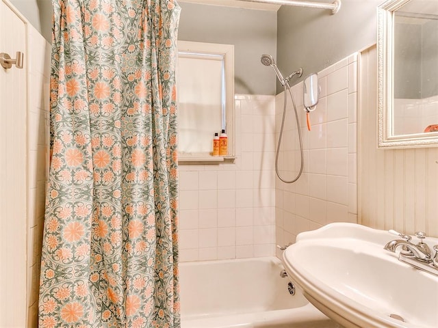 bathroom featuring shower / bath combination with curtain and a sink