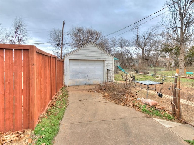 detached garage with driveway and fence