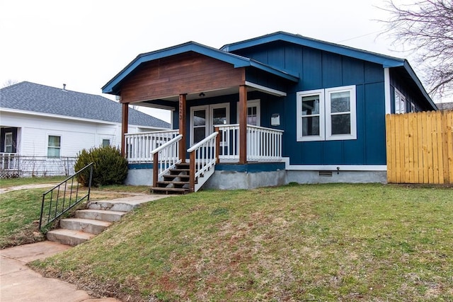 view of front of property with crawl space, fence, a porch, board and batten siding, and a front yard