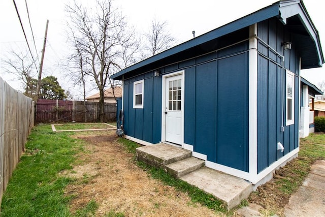 view of outbuilding with entry steps and a fenced backyard