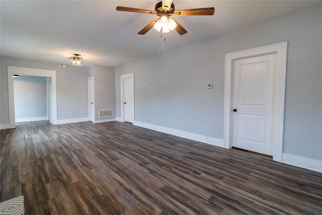 unfurnished room with a ceiling fan, dark wood-style flooring, visible vents, and baseboards