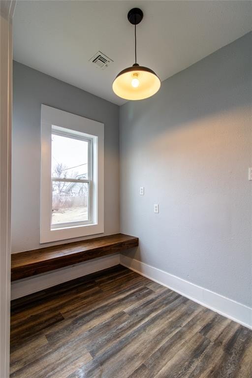 spare room featuring visible vents, baseboards, and dark wood-style flooring