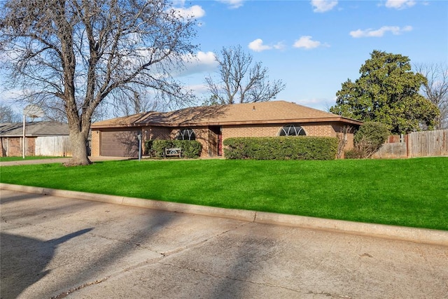 ranch-style house with brick siding, a garage, a front lawn, and fence