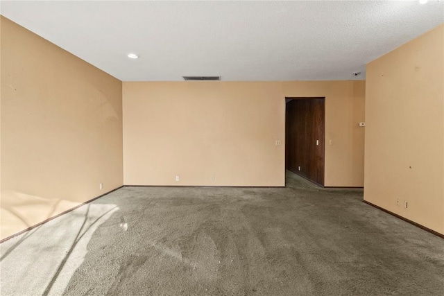 carpeted empty room featuring baseboards and visible vents