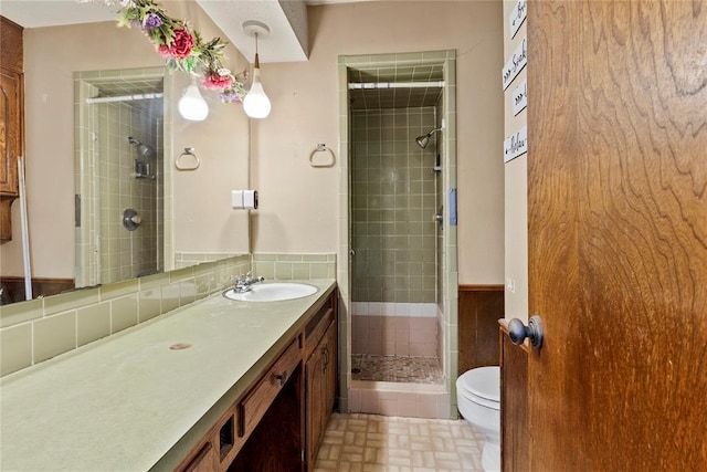 full bathroom featuring toilet, a stall shower, and vanity