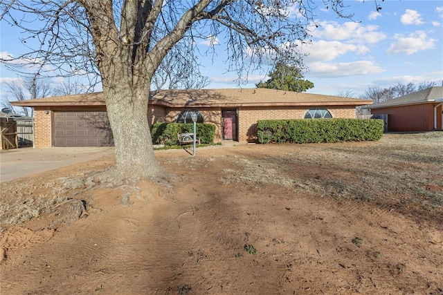 ranch-style house with a garage, brick siding, and driveway