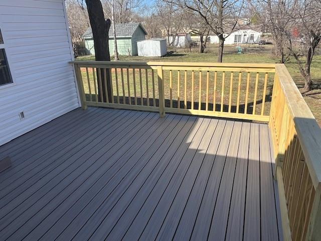 wooden terrace featuring a lawn