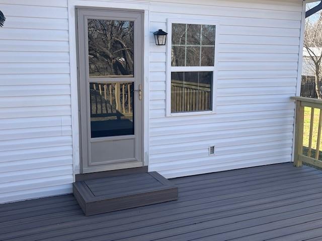 view of exterior entry with a wooden deck