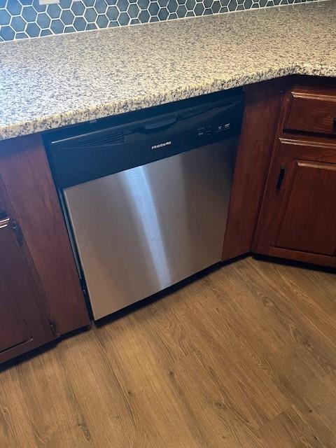 room details with light countertops, dishwasher, blue cabinetry, and wood finished floors