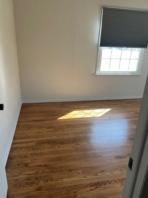 empty room with wood finished floors and baseboards