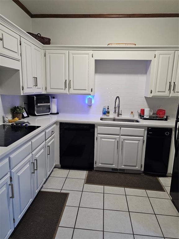 kitchen featuring white cabinets, black appliances, light countertops, and a sink