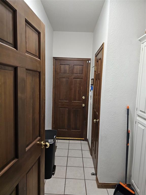 doorway with light tile patterned flooring