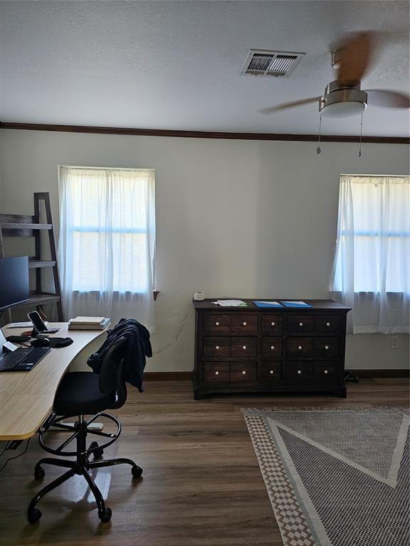 office area featuring visible vents, a textured ceiling, crown molding, baseboards, and dark wood-style flooring