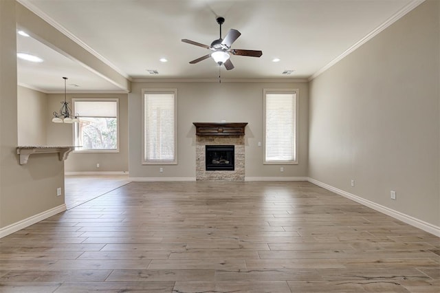 unfurnished living room with crown molding, ceiling fan, baseboards, a fireplace, and wood finished floors