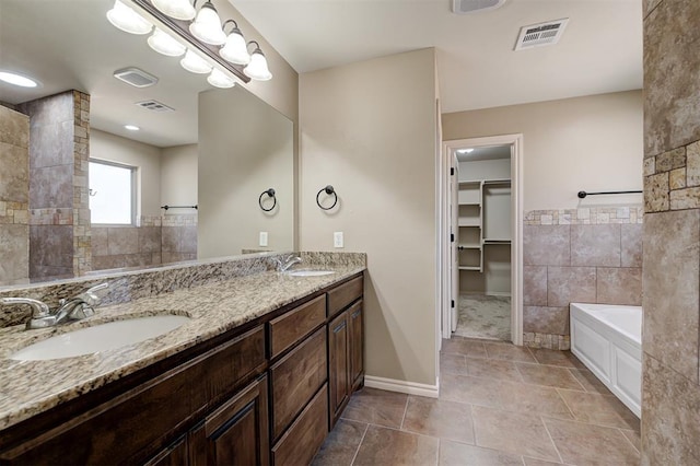 bathroom with a sink, visible vents, and a bath