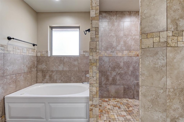 bathroom featuring walk in shower and a bath