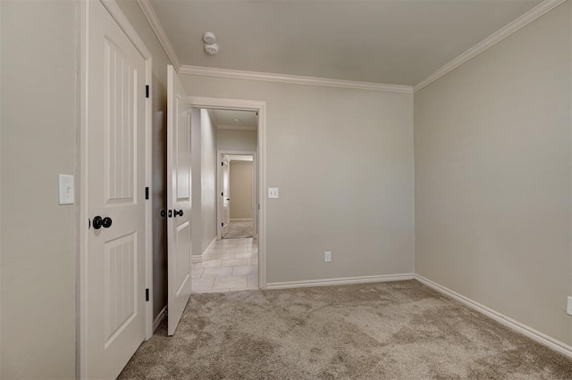 unfurnished room featuring ornamental molding, baseboards, and light carpet