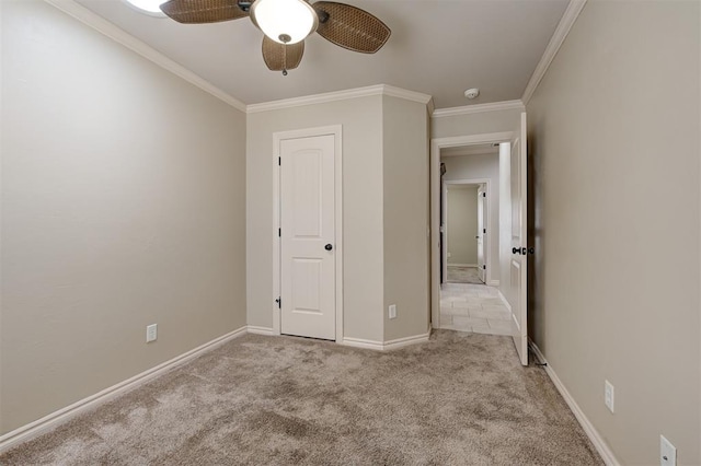 unfurnished bedroom featuring ceiling fan, carpet, baseboards, and ornamental molding