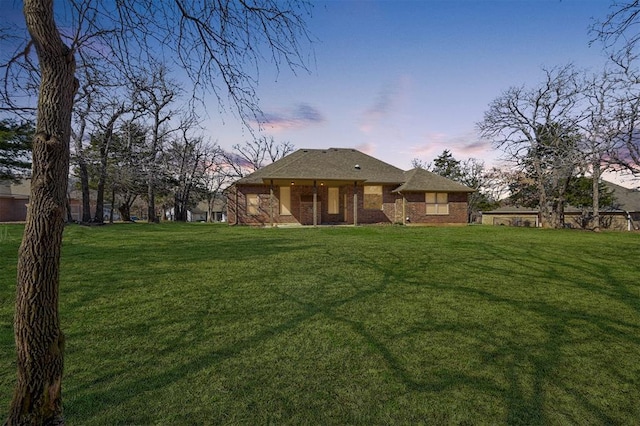 exterior space featuring brick siding and a front yard