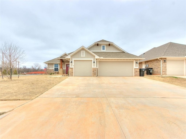 craftsman house with a garage, driveway, and a shingled roof