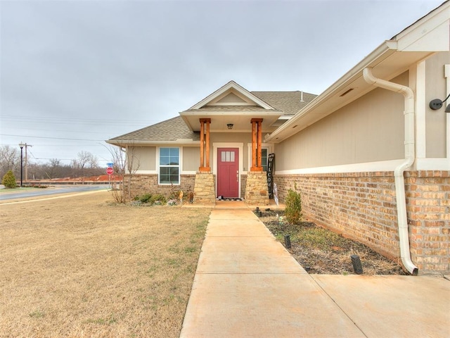 view of front of house featuring brick siding and a shingled roof