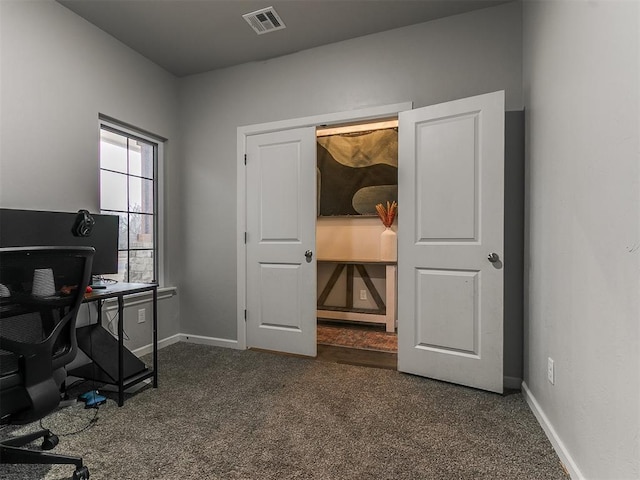 office area with dark colored carpet, visible vents, and baseboards