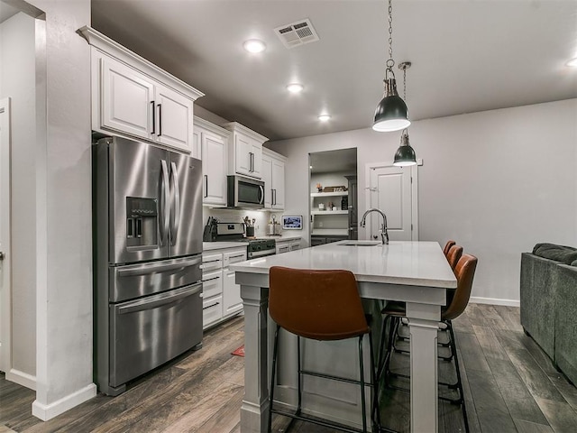 kitchen with light countertops, appliances with stainless steel finishes, dark wood-type flooring, and visible vents