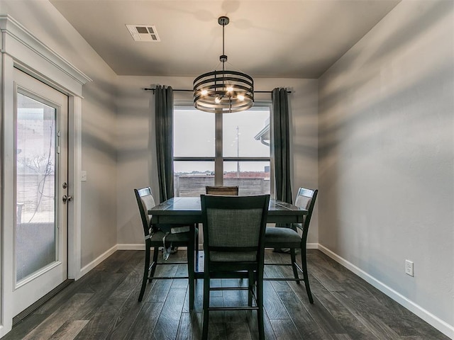 dining space featuring dark wood finished floors, visible vents, and baseboards