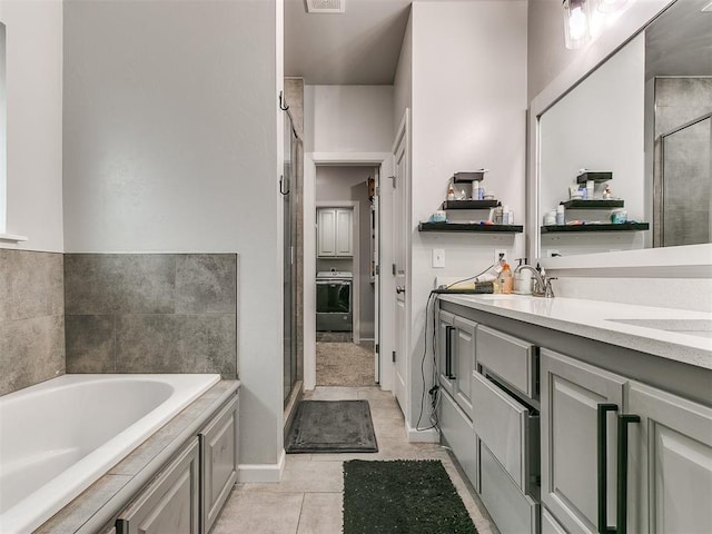 bathroom featuring a garden tub, visible vents, a stall shower, washer / dryer, and tile patterned flooring