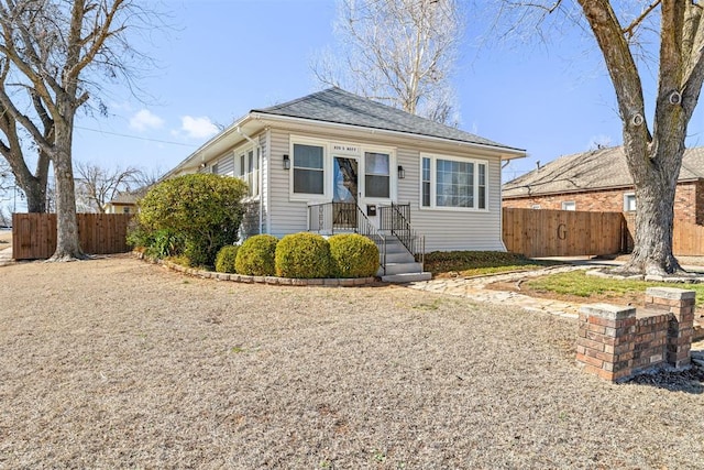 bungalow-style house with fence